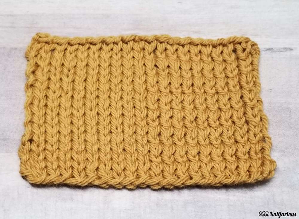 close up, angled view of swatch showing what purling through the back loop looks like on right side, while left side shows stockinette, i.e. standard purl stitches and knit stitches 